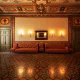 ...sono decorate con una serie di candelabri dorati e una specchiera in legno. Pi� in basso, le tonalit� accese delle trame dei divanetti...